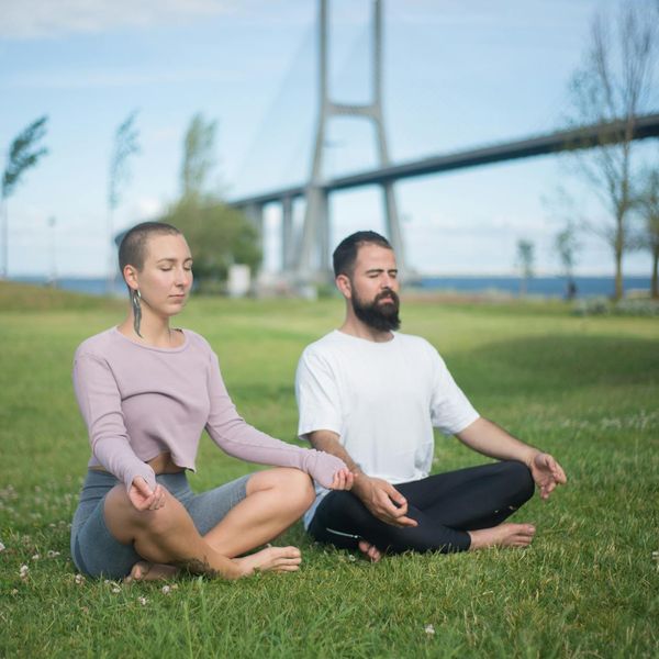 A person meditating peacefully in a natural outdoor setting.